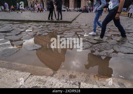 Rom, Italien. 24. Juni 2024. Das römische kolosseum spiegelt sich in einer Wasserpfütze nach Regenschauern am Ende einer Hitzewelle bei Temperaturen von 39celsius wider. Quelle: Amer Ghazzal/Alamy Live News Stockfoto