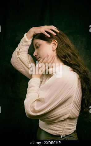 Junge Frau in weißer Plisseedbluse mit Händen, die ihren Kopf streicheln, spanien Stockfoto