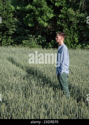 Porträt eines jungen Mannes im grünen ukrainischen Feld. Vertikale Seitenansicht. Stockfoto