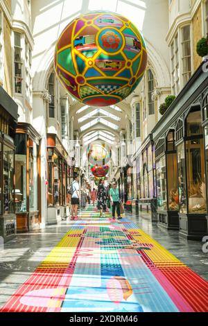 London, Großbritannien. Juni 2024. Die Burlington Arcade, die gehobene traditionelle Einkaufspassage im Londoner Mayfair, ist mit einem langen Teppichläufer im „Sporting Club“-Stil und riesigen Globus-Bälle dekoriert, in denen viele der Sportwettkämpfe des Sommers stattfinden, darunter Fußball, Olympische Sportarten und natürlich Tennis. Quelle: Imageplotter/Alamy Live News Stockfoto