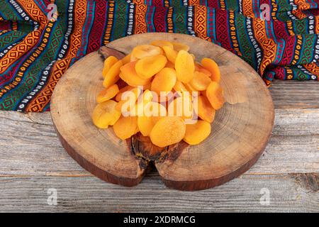 Natürlich getrocknete Aprikosen Farbe orange in einer Cupper Schüssel. Getrocknete Aprikosen im hölzernen Hintergrund. Leckere getrocknete Aprikosen als Hintergrund, Draufsicht. Gesundheit Stockfoto