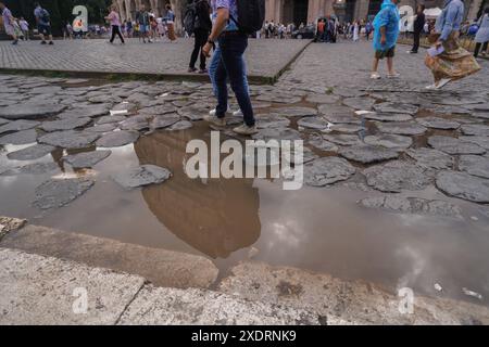 Rom, Italien. 24. Juni 2024. Das römische kolosseum spiegelt sich in einer Wasserpfütze während Regenschauer am Ende einer Hitzewelle bei Temperaturen von 39celsius wider. Quelle: Amer Ghazzal/Alamy Live News Stockfoto