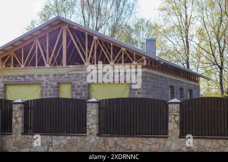 Neu gebautes Haus auf dem Land hinter einem Brettzaun Stockfoto