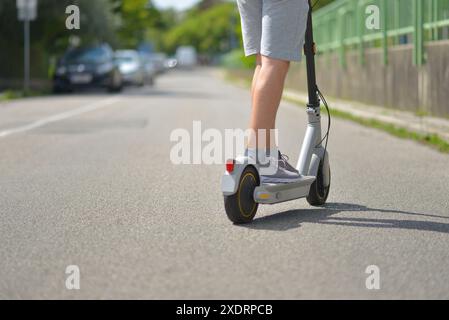 Nahaufnahme Mann, der auf einer Straße einen Elektroroller fährt. Das Konzept von Ökologie und gesundem Lebensstil in der Stadt. Stockfoto