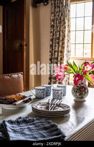 Tulpen und Beilagen mit Kuchen in der Küche des Tudor Farmhouse aus dem 16. Jahrhundert, Hertfordshire, England, Großbritannien. Stockfoto