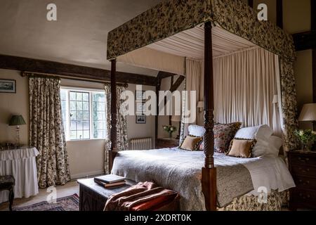 Georgianisches Himmelbett mit Chateaurenard-Stoff von Christopher Moore im 16. Jahrhundert Tudor Farmhouse, Hertfordshire, England, Großbritannien. Stockfoto