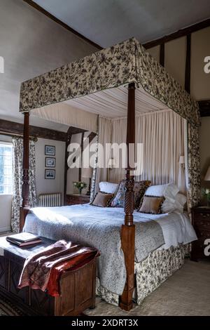 Georgianisches Himmelbett mit Chateaurenard-Stoff von Christopher Moore im 16. Jahrhundert Tudor Farmhouse, Hertfordshire, England, Großbritannien. Stockfoto