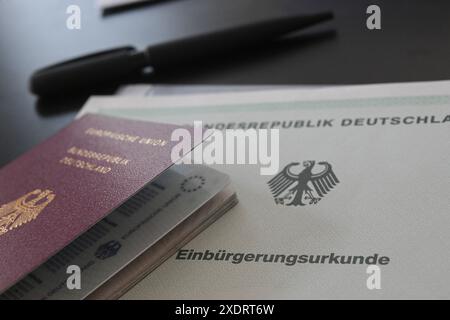 Stuttgart, Deutschland. Juni 2024. Ein deutscher Pass und ein Einbürgerungsschein liegen auf einem Tisch. Quelle: Marijan Murat/dpa/Alamy Live News Stockfoto