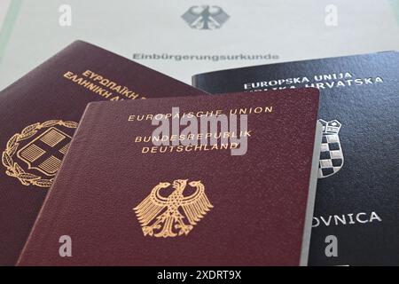 Stuttgart, Deutschland. Juni 2024. Ein kroatischer, ein deutscher und ein griechischer Reisepass sind auf einer Einbürgerungsbescheinigung zu finden. Quelle: Marijan Murat/dpa/Alamy Live News Stockfoto