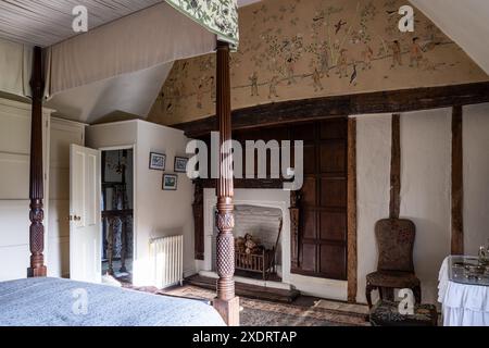 Georgianisches Himmelbett mit orientalischen Details über getäfeltem Kamin in Tudor Farmhouse aus dem 16. Jahrhundert, Hertfordshire, England, Großbritannien. Stockfoto