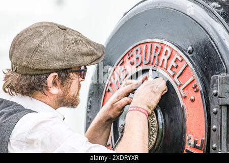 BROADCHALKE, WILTSHIRE, UK, 24. Juni 2024, Close Shot af ein Mann, der die Vorderseite einer Dampflokomotive beim Chalke History Festival reinigt, dem führenden Geschichtsfestival Großbritanniens am Eröffnungstag, das Hunderttausende von Geschichtsbegeisterten anzieht (darunter Zehntausende von Schulkindern während des speziellen Schulfestivals an den ersten beiden Tagen). John Rose/Alamy Live News Stockfoto