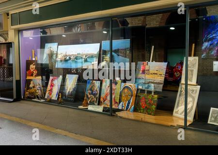 Sevilla, Spanien. 5. Februar 2024 – farbenfrohe Gemälde in einem Schaufenster auf der Plaza de Armas Stockfoto