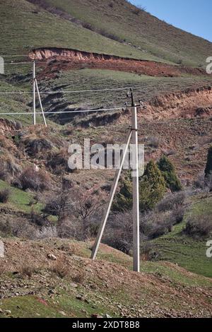 Zwei Betonsäulen, alte Stromleitung mit kleinen Stromflüssen bei niedrigen Haushaltsspannungen auf dem Land. Elektrische Übertragung, die Elektronen trägt Stockfoto