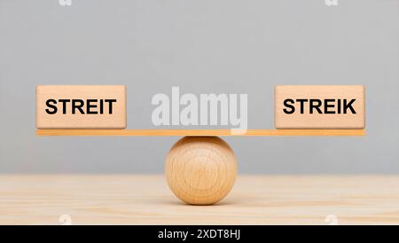 Streit und Streik Streit und Streik liegen im Gleichgewicht auf einer Wippe *** Streik und Streik sind auf einer Wippe ausgeglichen Stockfoto