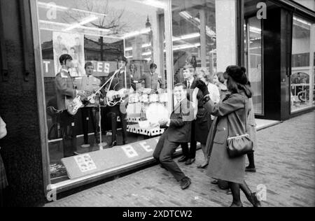 Beatlemania - Beatles Fans - 1960er Jahre Mode - Beatles im Fenster der Modekette Kreymborg am Grote Markt in Haarlem, 1964 Stockfoto