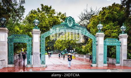 Berkeley, Kalifornien, USA - 24. März 2017: UC Berkeley Student Tourguide passiert an einem regnerischen Tag den Eingang zum Sather Gate. Stockfoto