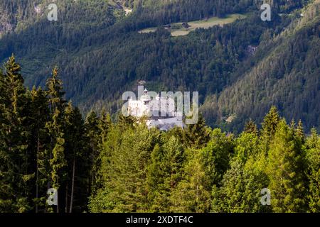 Das etwa 900 Jahre alte Schloss Hohenwerfen und das Tennengebirge erheben sich hinter dichten Fichtenwäldern über dem Salzachtal bei Werfen, Salzburg, Österreich. Der Blick ist von einem Original-Drehort des Films „The Sound of Music“ von 1965 mit Julie Andrews und Christopher Plummer. Stockfoto