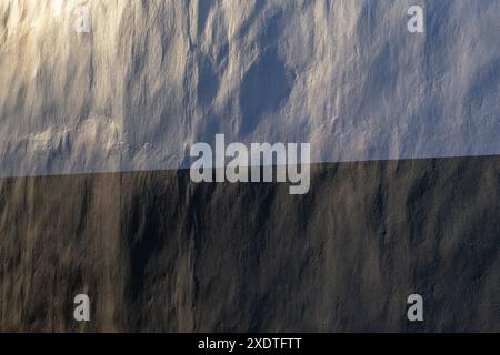 Nahaufnahme einer sauberen und unebenen Wand in weiß und Schwarz. Schönes Seitenlicht erzeugt weiche Schatten. Abstrakter texturierter Hintergrund, Kopierraum. Stockfoto
