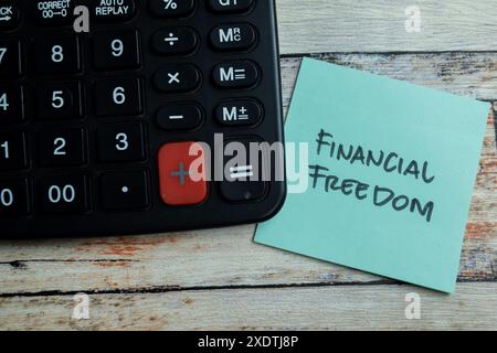 Konzept der finanziellen Freiheit Schreiben Sie auf Haftnotizen isoliert auf Holztisch. Stockfoto
