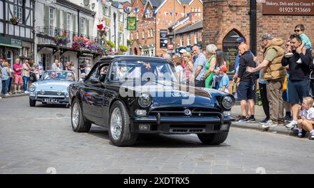 Lymm Village, Cheshire, England   23. Juni 2024   Lymm Village ließ seine jährliche Kavalkade historischer Fahrzeuge durch seine Straßen fahren. Der Drive endete auf dem May Queen Field, das für die Öffentlichkeit zugänglich war. Über 450 klassische Autos, darunter Militärfahrzeuge wie Panzer und Jeeps, amerikanische Fahrzeuge und Motorräder, wurden ausgestellt. Quelle: John Hopkins/Alamy Live News Stockfoto