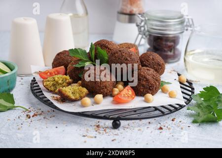 Stehen Sie mit köstlichen Falafelbällchen, Kichererbsen und Tomaten auf hellem Hintergrund Stockfoto