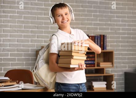 Teenager in Kopfhörern mit Büchern in der Bibliothek Stockfoto