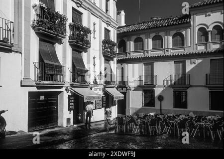 Mann wäscht die Straße vor einem Restaurant in Cordoba, Andalusien, Spanien Stockfoto