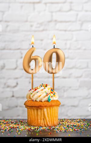 Cupcake mit Nummer 60 Geburtstagskerze - weißer Block Wand Hintergrund Stockfoto