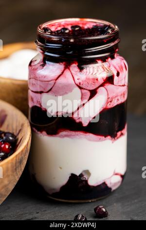 Frischer cremiger Joghurt mit Beeren und Heidelbeermarmelade, hausgemachter Joghurt mit Reifen Heidelbeeren und Heidelbeermarmelade Stockfoto