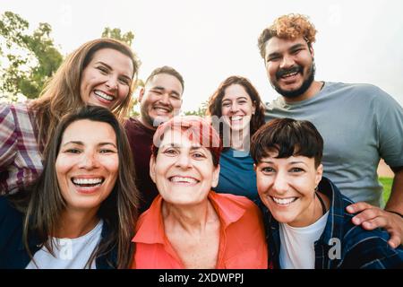 Multirassische Freunde mit unterschiedlichem Alter und ethnischer Herkunft haben Spaß beim Selbstporträt in Park City. POV von Leuten, die auf dem Handy lächelten, kam Stockfoto