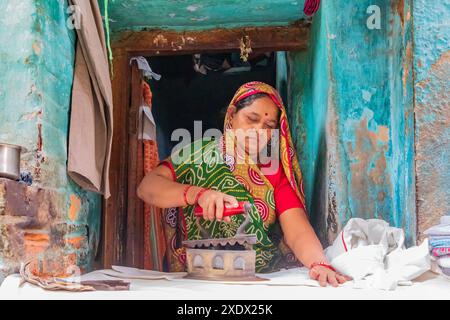 Indien, Uttar Pradesh, Varanasi, Bangali Tola. Frau bügelt. Stockfoto