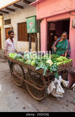 Indien, Uttar Pradesh, Varanasi, Bangali Tola. Mann, der Gemüse aus einem Wagen verkauft. Stockfoto