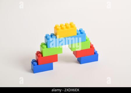 Eine regenbogenfarbene lego Treppe isoliert auf weißem Hintergrund. Bausteine Stockfoto