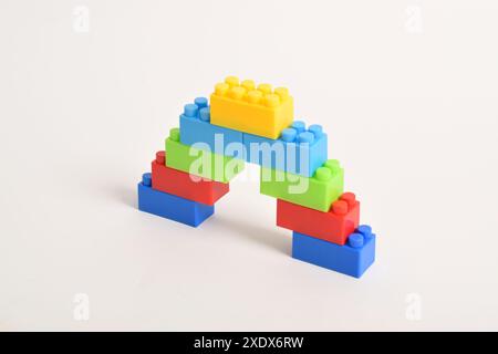 Eine regenbogenfarbene lego Treppe isoliert auf weißem Hintergrund. Bausteine Stockfoto