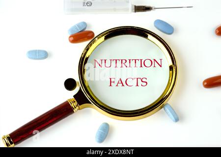 Viele Nutrition Facts-Texte, geschrieben durch eine Lupe auf weißem Hintergrund Stockfoto