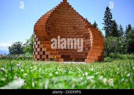 Eine Spirale aus Ziegeln, die auf einem grasbewachsenen Feld steht und eine einzigartige architektonische Formvorbereitung für das Braten und Grillen schafft. Stockfoto