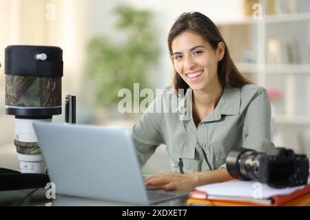 Porträt eines glücklichen Fotografen, der zu Hause in die Kamera schaut Stockfoto