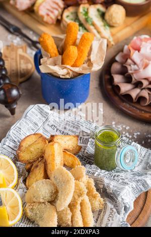 Köstliche Auswahl: Gebratene Kartoffelscheiben, Fischstäbchen und verschiedene Fleischgerichte mit Dip-Sauce Stockfoto