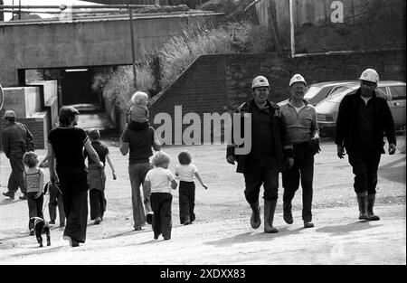 Steinkohlebergarbeiter, die in Richtung der Grubenkantine oder des Pithead-Bades gehen. Die Familien gehen zu einem gemeinsamen Ritus über die U-Bahn in Richtung South Kirkby. South Kirkby Colliery, Yorkshire, England 1979 1970er Jahre HOMER SYKES Stockfoto