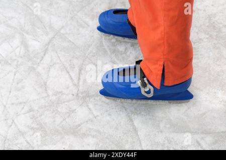 Schlittschuhstiefel mit dreifachem Verschluss an den Beinen eines Teenagers auf dem Eis Stockfoto