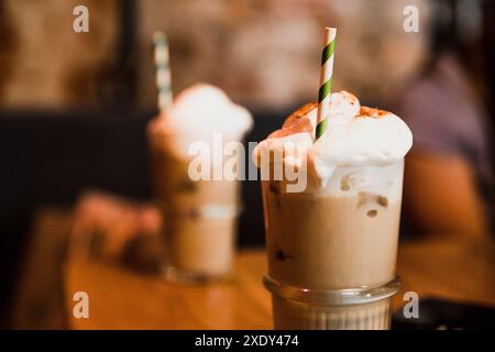 Schokoladenmilchschatten oder Eiskaffee mit Schlagsahne und Strohhalm, serviert in einem Restaurant Stockfoto