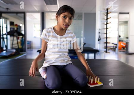 Im Rehabilitationszentrum spielt Mädchen mit Zerebralparese mit Therapiespielzeug auf dem Tisch Stockfoto