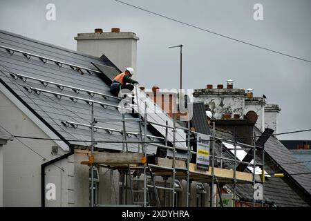 Arbeiter, die Solarpaneele auf einem Dach in Ardara, County Donegal, Irland installieren. Stockfoto