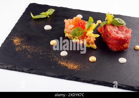 Lachs- und Rindfleisch-Tatar auf schwarzem Brett Stockfoto
