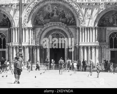 Venedig, Italien - 30. Juni 20220 Touristen, die auf dem Markusplatz spazieren gehen, mit Tauben, die in venedig herumfliegen Stockfoto