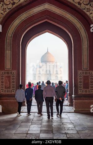 Agra, Indien - 8. November 2018: Fantastischer Blick am frühen Morgen auf das Taj Mahal durch den bogenförmigen Eingang zu den Gärten des Komplexes. Stockfoto