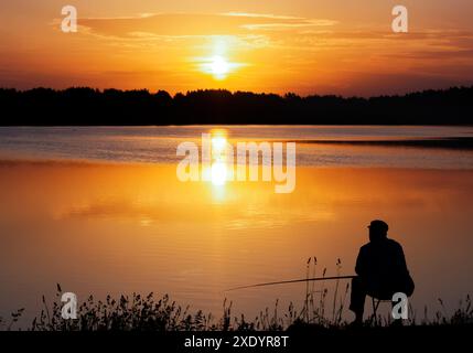 Fisherman-Silhouette. Sonnenaufgang über dem See am frühen Morgen. Stockfoto