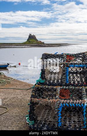 Lindisfarne Castle vom Pier aus als Hintergrund zu einem kleinen Stapel von Hummer-/Creel-Töpfen, Holy Island of Lindisfarne, Northumberland, England Stockfoto