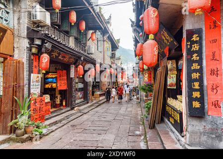 Fenghuang, China - 23. September 2017: Fabelhafter Blick auf die gemütliche enge Straße, die mit traditionellen orientalischen chinesischen roten Laternen dekoriert ist. Stockfoto