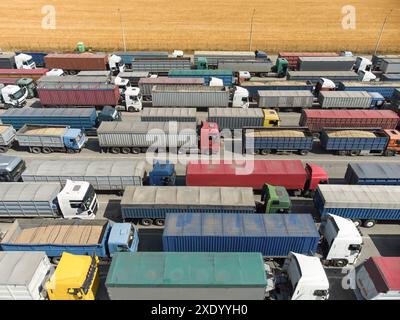 LKW in der Schlange, um Getreide im Hafen zu entladen. Luftaufnahme von vielen Lastwagen mit Anhängern. Stockfoto